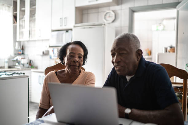 Senior couple using laptop at kitchen